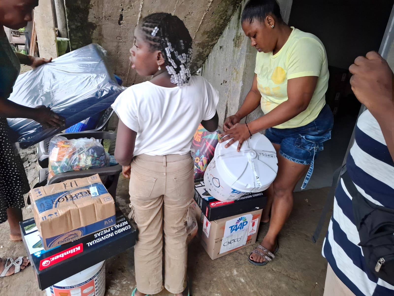 Una niña y su mamá abriendo la caja con el filtro y el kit de mercado